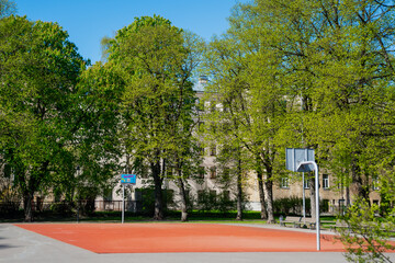 Obraz premium Empty basketball court in green tree park in city