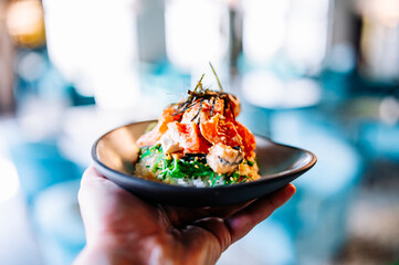 man hand hold shrimp poke with rice and vegetables in bowl