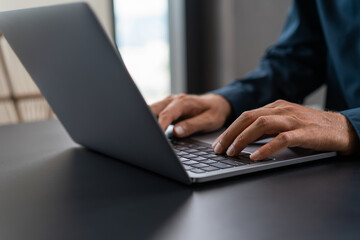 Businessman in blue shirt using laptop