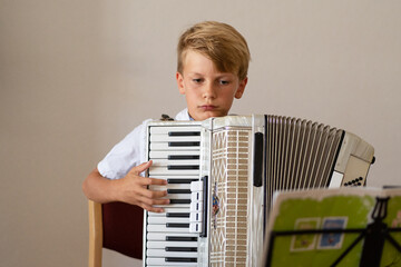 Boy teen focusing on playing an piano accordion, professional accordionist
