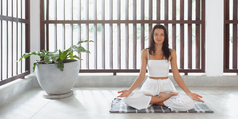 Yoga for the Soul: Meditative Woman in Lotus Pose Practicing Indoors