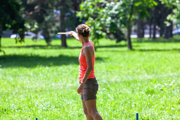 Young woman playing flying disc sport game in the park