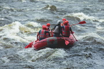 Red raft boat during whitewater rafting extreme water sports on water rapids, kayaking and canoeing on the river, water sports team with a big splash of water