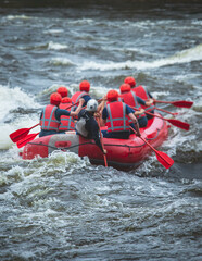 Red raft boat during whitewater rafting extreme water sports on water rapids, kayaking and canoeing on the river, water sports team with a big splash of water