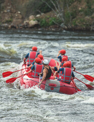 Red raft boat during whitewater rafting extreme water sports on water rapids, kayaking and canoeing...