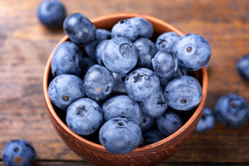 Freshly picked blueberries in  bowl. Bilberry on wooden Background. Blueberry antioxidant. Concept for healthy eating and nutrition