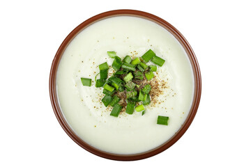 Cauliflower cream soup in a clay plate isolated white background.