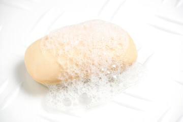 Piece soaped toilet soap with foam white background.