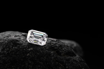 Emerald cut diamond on black natural stone