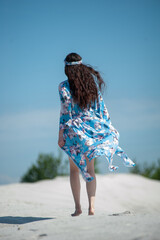 Beautiful woman on a sand beach in blue beachwear