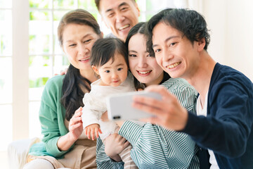 スマホで自撮りする赤ちゃんと家族