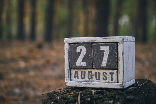 August 27 summer month, wooden calendar with date and month in forest.