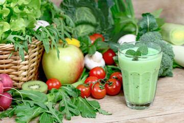 Homemade green smoothie and ingredients, green smoothie with fresh vegetables and fruits on the wooden table - 599874869