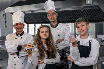 Teenagers learn from expert chefs at culinary school to prepare ingredients and create a variety of...