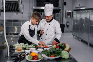 Teenagers learn from expert chefs at culinary school to prepare ingredients and create a variety of tasty meals. A practical activity connected their senses of taste and smell is making hamburgers. - obrazy, fototapety, plakaty