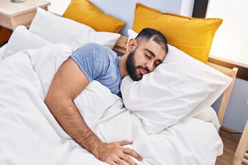 Young hispanic man lying on bed sleeping at bedroom