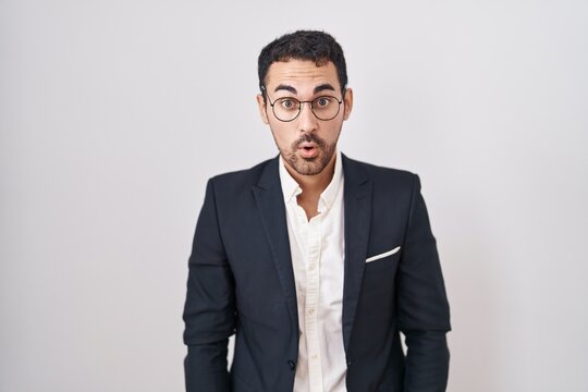 Handsome business hispanic man standing over white background afraid and shocked with surprise and amazed expression, fear and excited face.