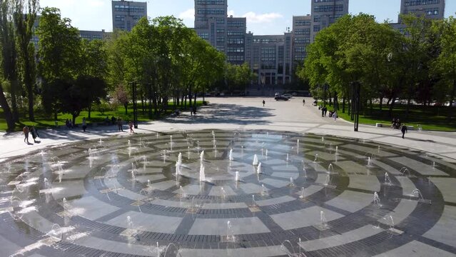 Aerial dolly view on Derzhprom building with fountain and green park in spring on Freedom (Svobody) Square in Kharkiv city center, Ukraine