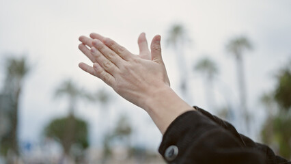 Young beautiful hispanic woman clapping applause at street