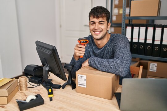 Young hispanic man ecommerce business worker scanning package at office