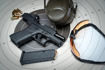 Shooting range from a weapon at a target, pistol, target, goggles and headphones.