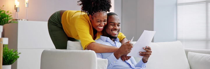 Happy Young African Couple Reading Letter