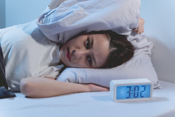 Asian women opened eyes lying on the bed have an insomnia problems.