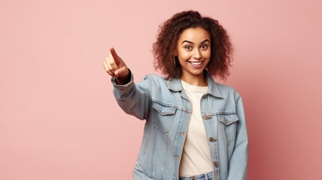 Attractive woman with happy expression advices use this copy space wisely, dressed in fashionable denim jacket, points with thumb aside, models against pink background. generative ai