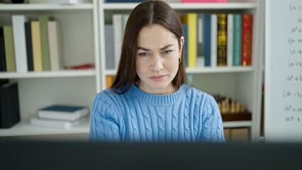 Young caucasian woman student using computer studying at library university