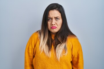 Fototapeta premium Young hispanic woman standing over isolated background depressed and worry for distress, crying angry and afraid. sad expression.