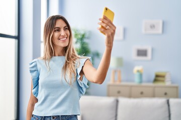 Young woman make selfie by smartphone standing at home