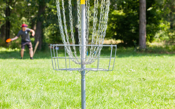 Disc golf player throwing a flying disc in the park