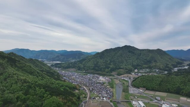Cloud pattern over houses in small town and mountain landscape
