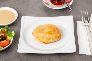 Izmir boyoz on a white porcelain plate on a stone table