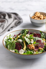 Healthy Salad made from Green Salad Leaves, Rocket Salad, Slices of Beetroot, Avocado, pieces of Feta Cheese, Walnuts and Sesame Seeds.