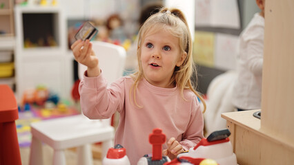Adorable blonde girl smiling confident playing at kindergarten