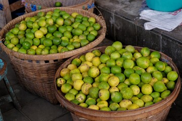 Pile of citrus fruits in a basket at a traditional market stall.