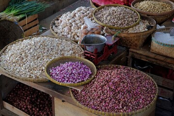 Assorted onions in a traditional market stall.