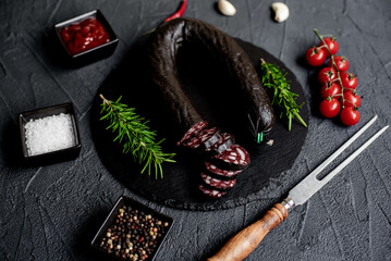 Spanish black pudding or blood sausage with rosemary on a stone background