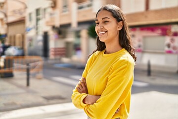 Young african american woman smiling confident standing with arms crossed gesture at street