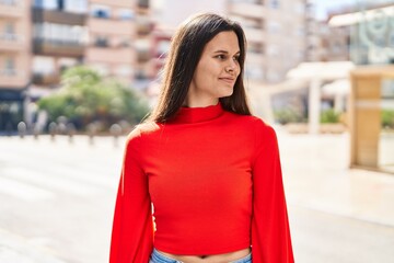 Young beautiful hispanic woman smiling confident looking to the side at street