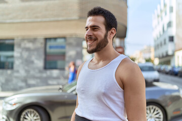 Young hispanic man smiling confident standing at street