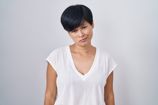 Young asian woman with short hair standing over isolated background depressed and worry for distress, crying angry and afraid. sad expression.