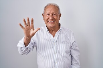 Fototapeta premium Senior man with grey hair standing over isolated background showing and pointing up with fingers number five while smiling confident and happy.