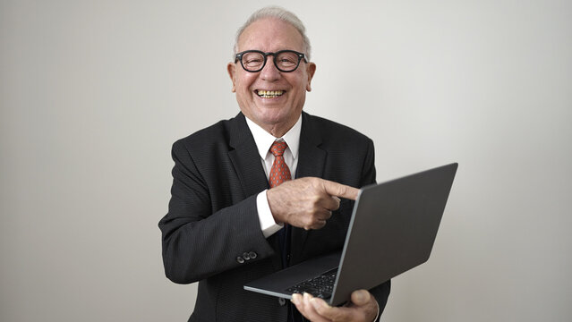 senior standing pointing to laptop over isolated white background