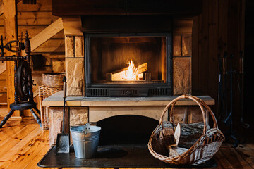 Indoor Fireplace Safety. How to Safely Use and Maintain a Wood-Burning Fireplace. Fireplace, wicker basket for firewood, pile of logs for a fire - obrazy, fototapety, plakaty