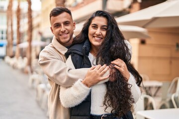 Fototapeta premium Man and woman couple hugging each other standing at street