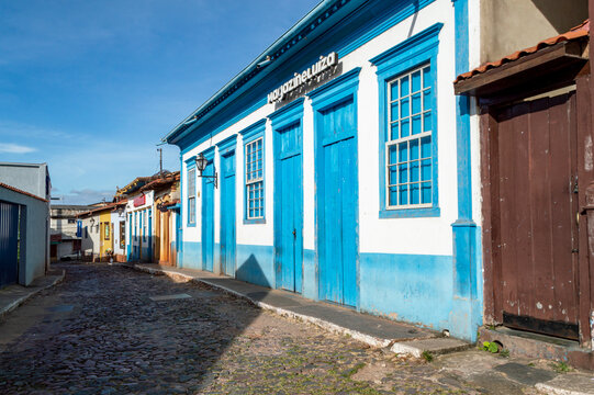 Beautiful colorful old mansions in the historic city of Sabar&aacute;. Brazil. Magazine Luiza store in Sabar&aacute;. Blue sky. Stone-paved street. Horizontal.