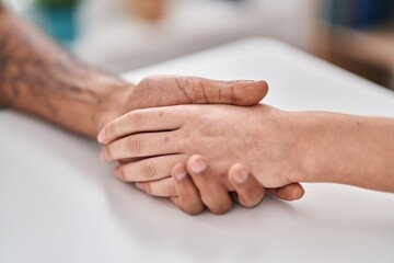 Fototapeta premium Man and woman couple sitting on table with hands together at home