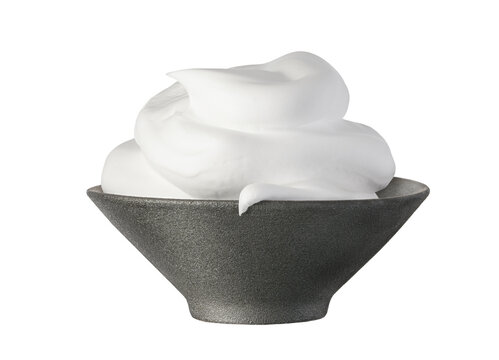 White shaving foam, cosmetic foam mousse, cleanser in black ceramic bowl isolated on white background. Skin care foamy product
